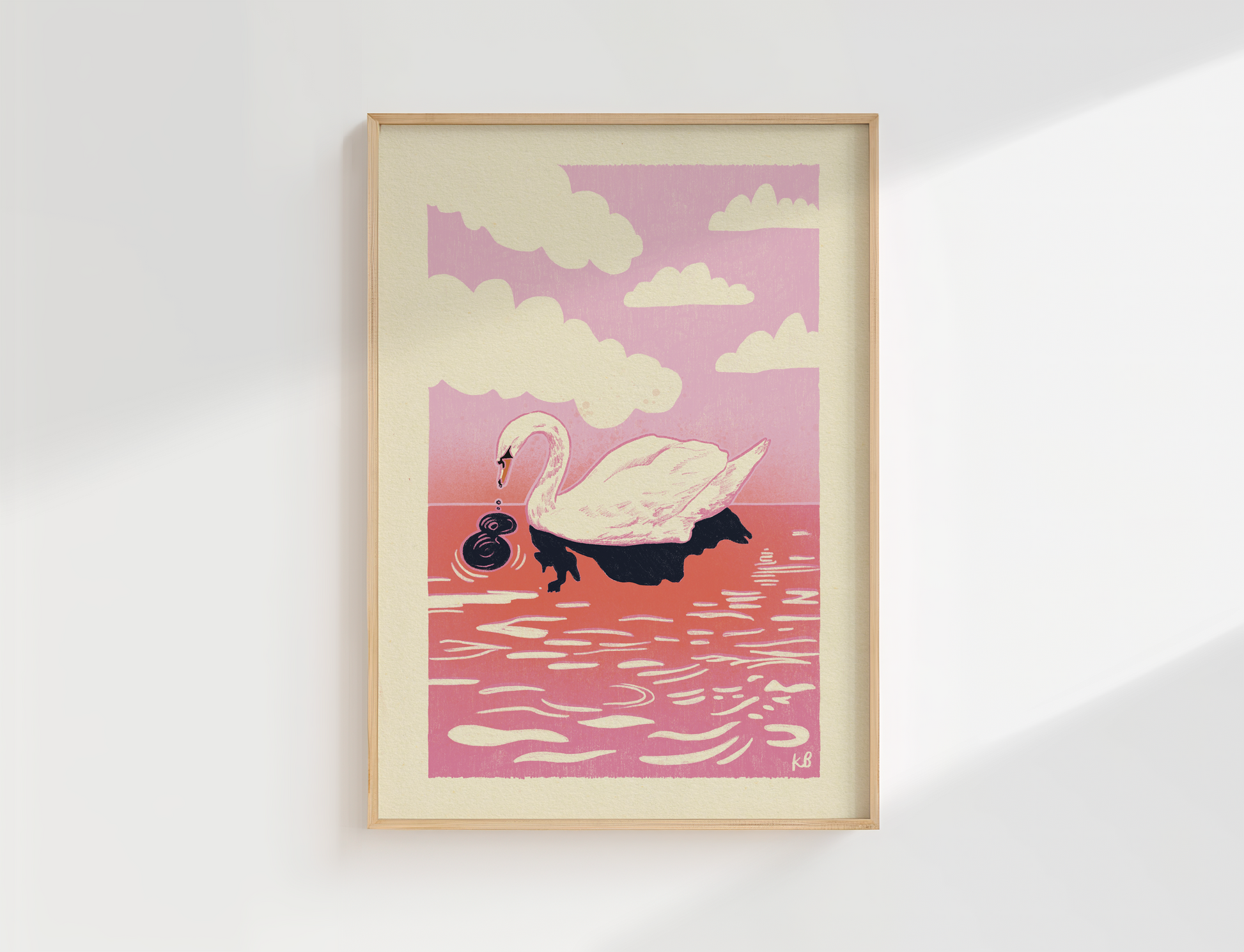 Framed artwork of a swan on water with a pink sky and clouds, displayed on a white wall.