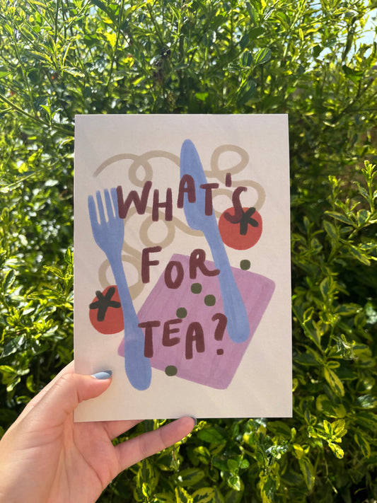 A hand holds an A5 art print in front of dense green foliage. The card features a hand-painted style illustration with the text 'WHAT'S FOR TEA?' in dark brown lettering over blue cutlery, red tomatoes, green peas, and a purple napkin.